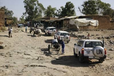 Billedet viser en konvoj af FN-biler, som kører gennem en landsby i Darfur i 2010. Konvojen er en del af den fredsbevarende styrke UNAMID. Foto: UN Photo/Albert González Farran.